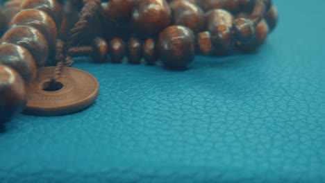 Macro-pan-shot-of-a-wooden-round-beads-necklace-with-coin-medallion