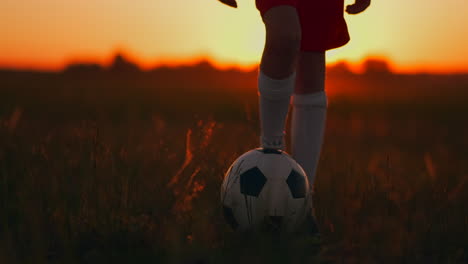 Un-Niño-Corre-Por-El-Campo-Al-Atardecer-Con-Una-Pelota-De-Fútbol.-Regatear-Con-La-Pelota