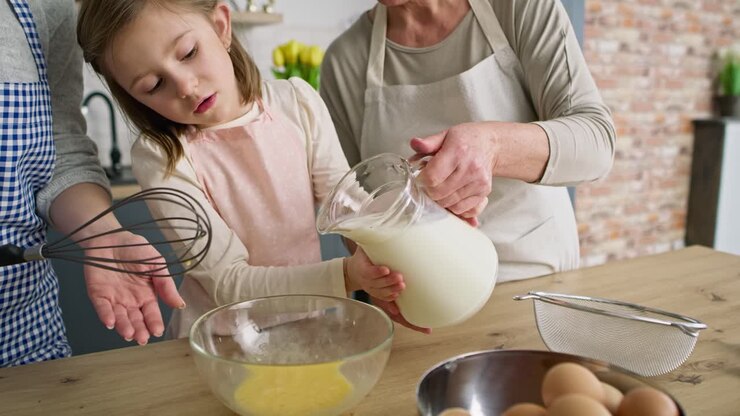 Video of girl helping mother and grandma in the kitchen
