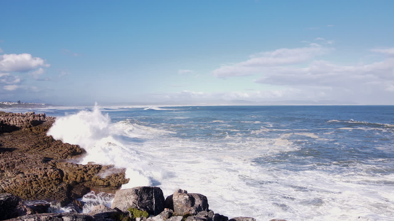 해안선의 거친 해안에 파도 부 ⁇ 히는 절벽 바위 위의 낮은 공중