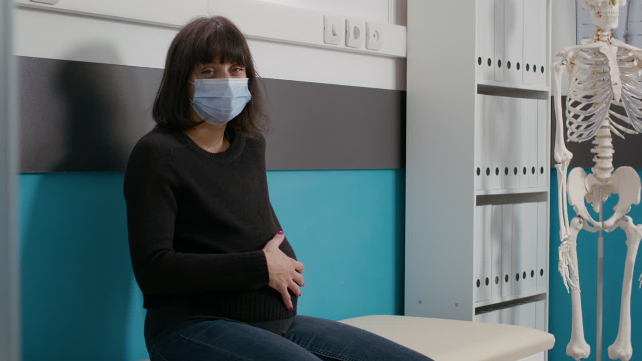 Portrait of female patient expecting child in checkup office