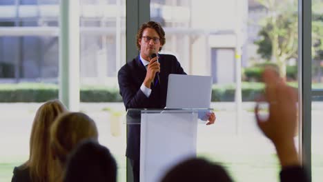 orador masculino con computadora portátil habla en un seminario de negocios 4k