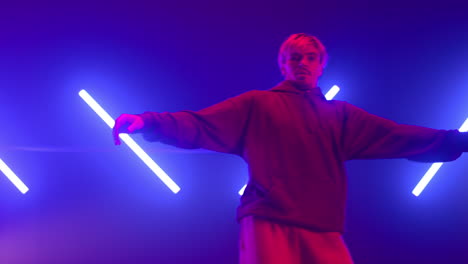 guy dancing street style in neon backlit. stylish b-boy enjoying freestyle.