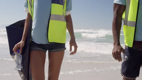 voluntarios caminando con bolsas de basura en la playa 4k