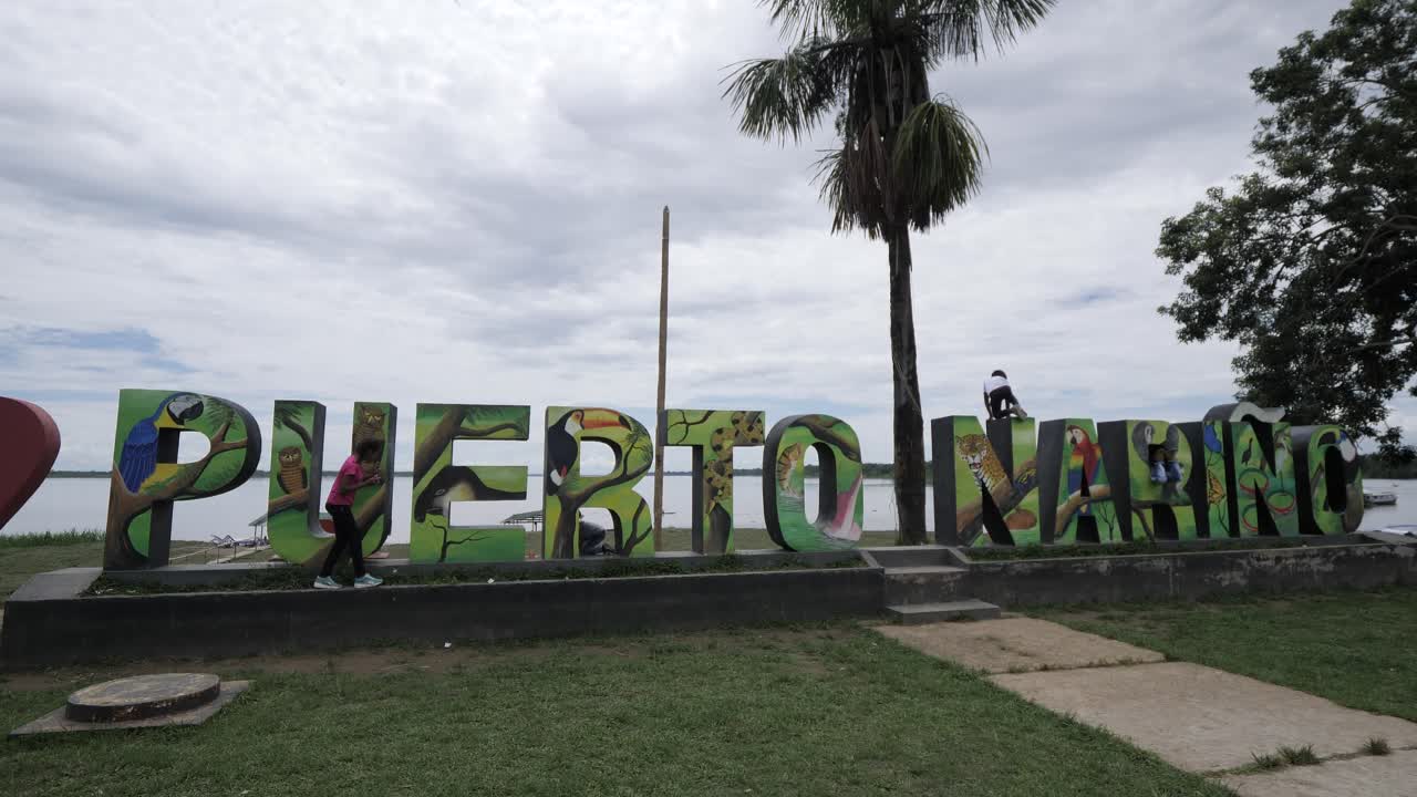 Children and teenagers playing around the port of Narino, Colombia. The green Amazon jungle area at midday.