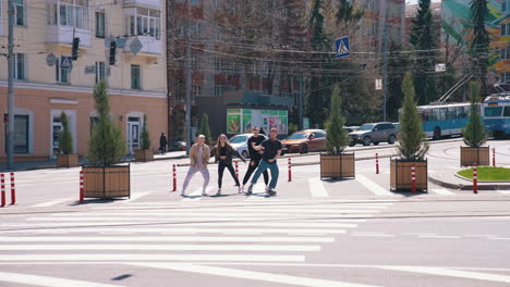 happy friends dancing at the road. group of young people having fun outdoors. guys enjoy their life together concept