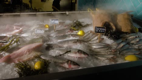 fish is displayed on top of ice, inside a restaurant