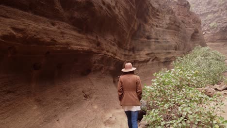 woman walking inside in ravine with big stones&quot;