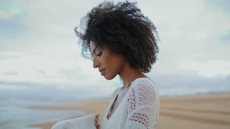 vertical worried woman look sea on gloomy day closeup. thinking african american