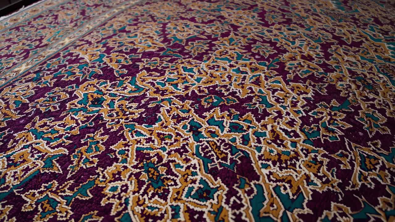 Traditional persian carpet displaying a mesmerizing mix of purple, gold, and teal in an elaborate floral pattern, adding a touch of elegance and cultural richness