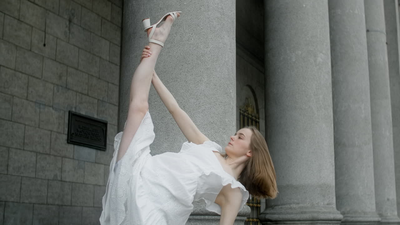 балетная танцовщица растягивается на открытом воздухе