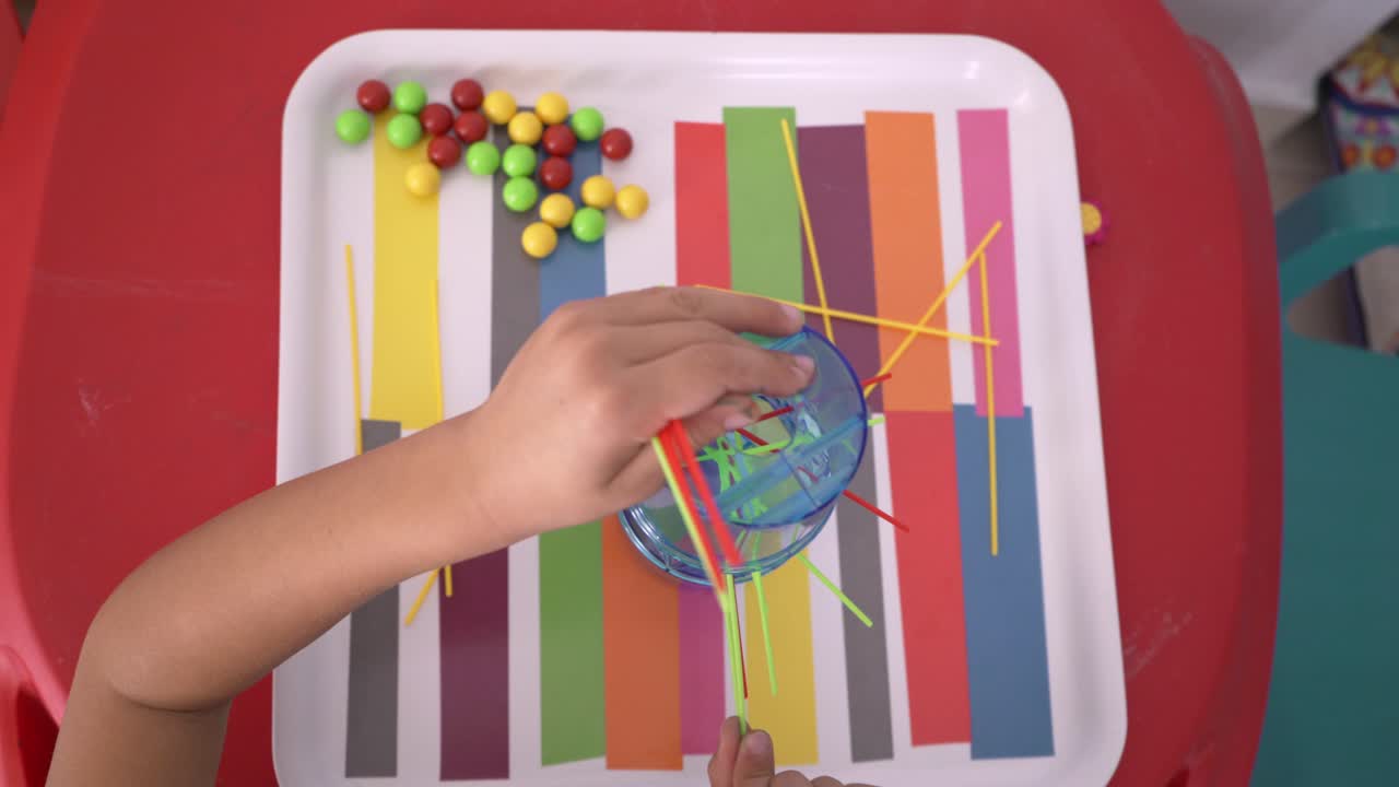 niño caucásico de cuatro años jugando al juego clásico kerplung en casa, vista alta 4k