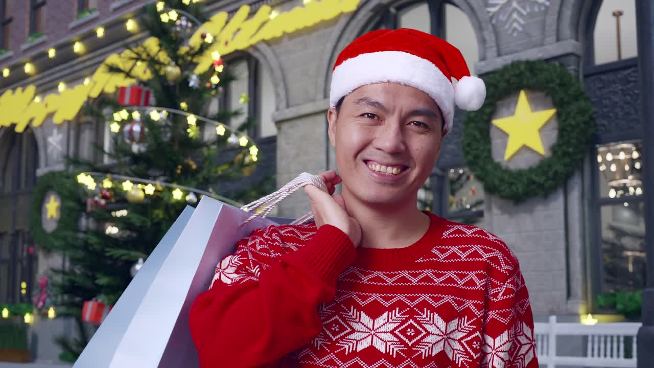 close up de hombre asiático en traje de navidad con las bolsas de compras sonriendo a la cámara mientras está de pie en la noche de navidad