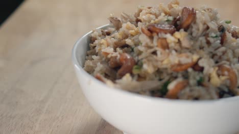 Close-Slow-Motion-Slider-Shot-of-Sprinkling-Green-Spring-Onions-on-a-Bowl-of-Egg-Fried-Rice