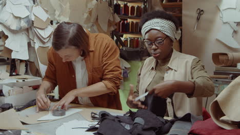 multiethnic female shoemakers working together in workshop