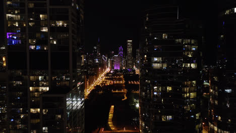 drone flies between chicago skyscrapers at night