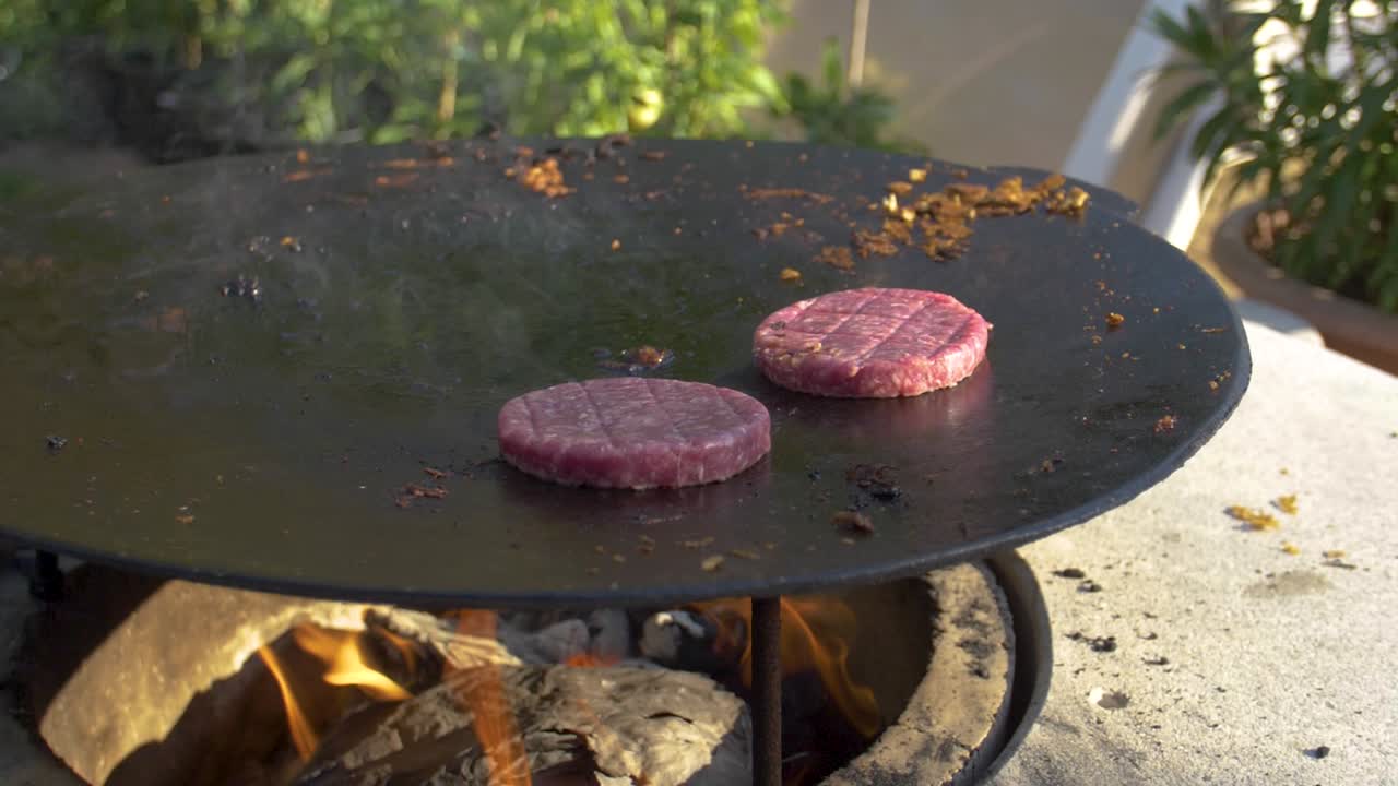 hamburguesa asada a la parrilla en chapa de hierro sobre fuego -180fps a cámara lenta