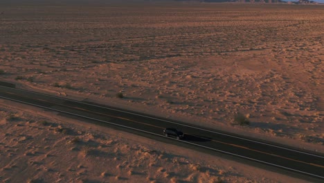 modern black car driving in the desert on a street from california to arizona