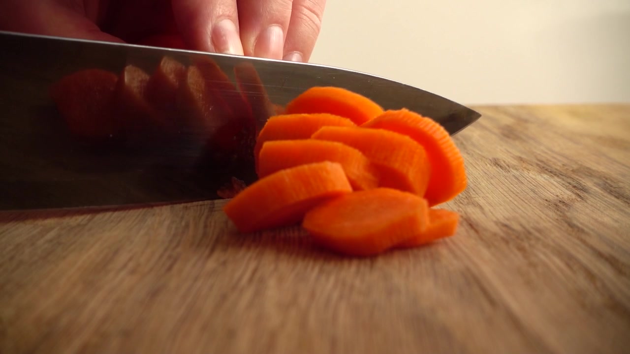 Kokken skærer gulerødder. Slowmotion