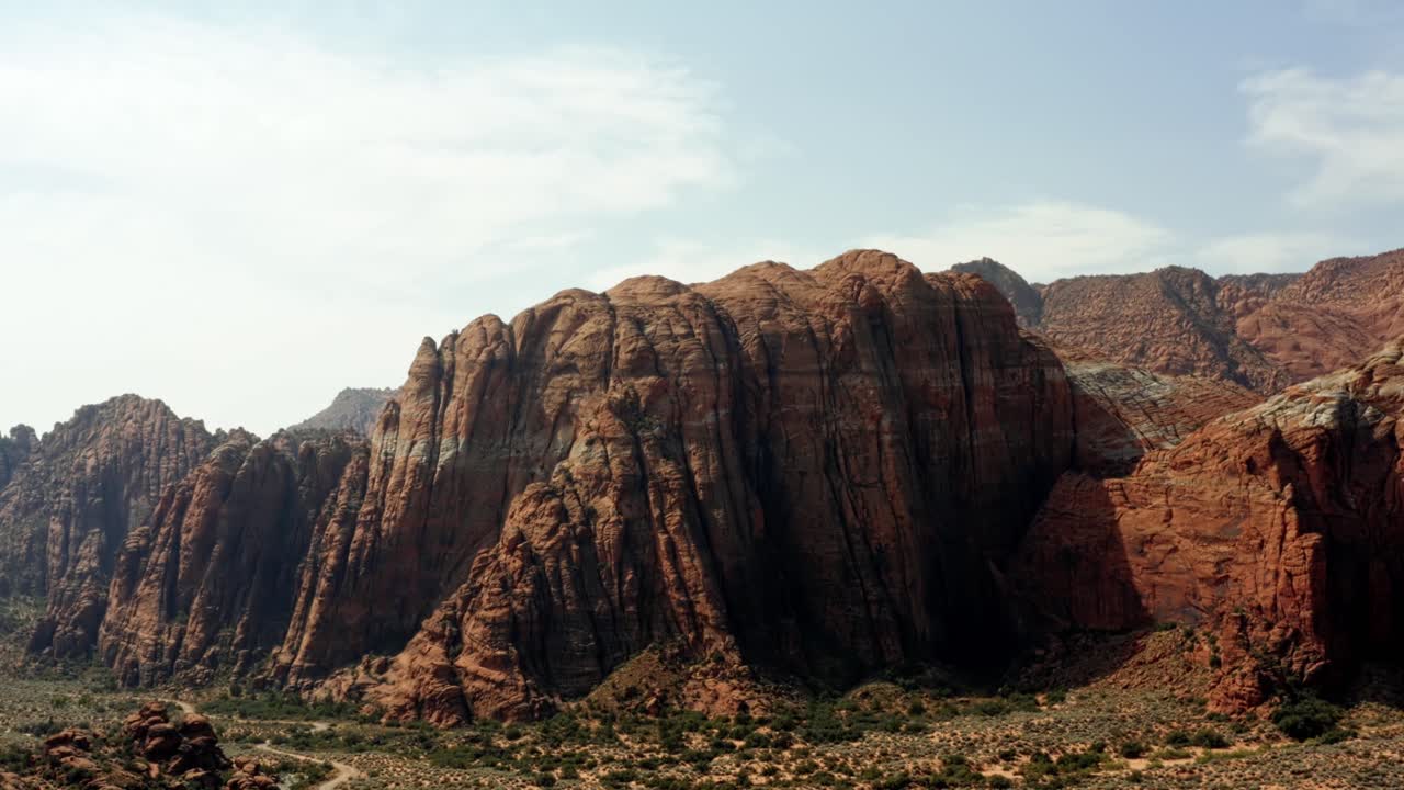 hermoso paisaje de drones aéreos naturaleza tiro ascendente de impresionantes formaciones de roca roja con dunas de arena petrificadas secas debajo en una caminata en el parque estatal del cañón de nieve, utah en un cálido día soleado de verano