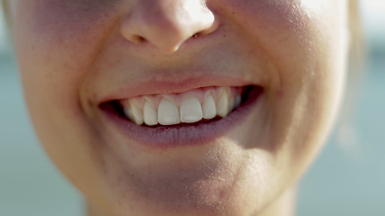 un primer plano de una mujer joven con una sonrisa dentada.