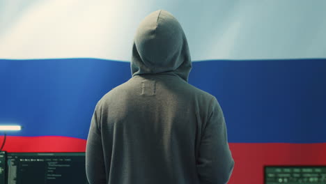 Ein-Russischer-Hacker,-Der-In-Einem-Staatlichen-Hacking-Raum-Mit-Der-Russischen-Flagge-Arbeitet