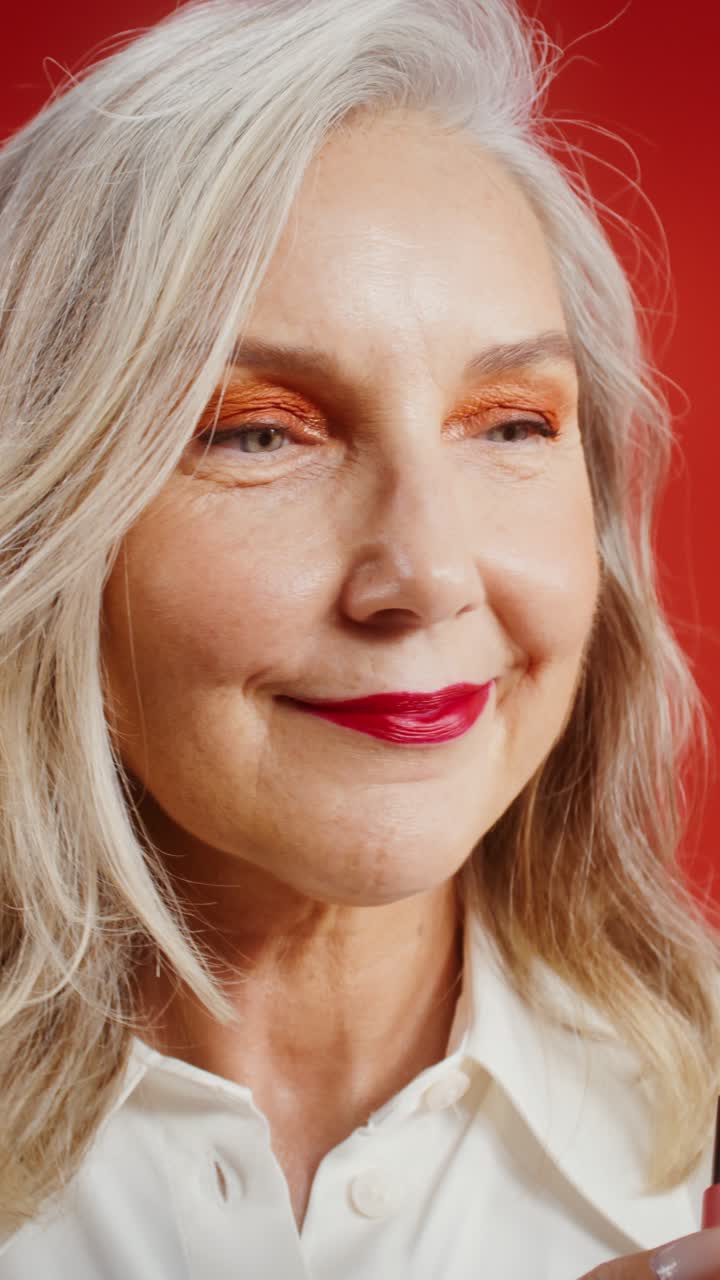 Portrait of a Mature Woman Applying Red Lipstick