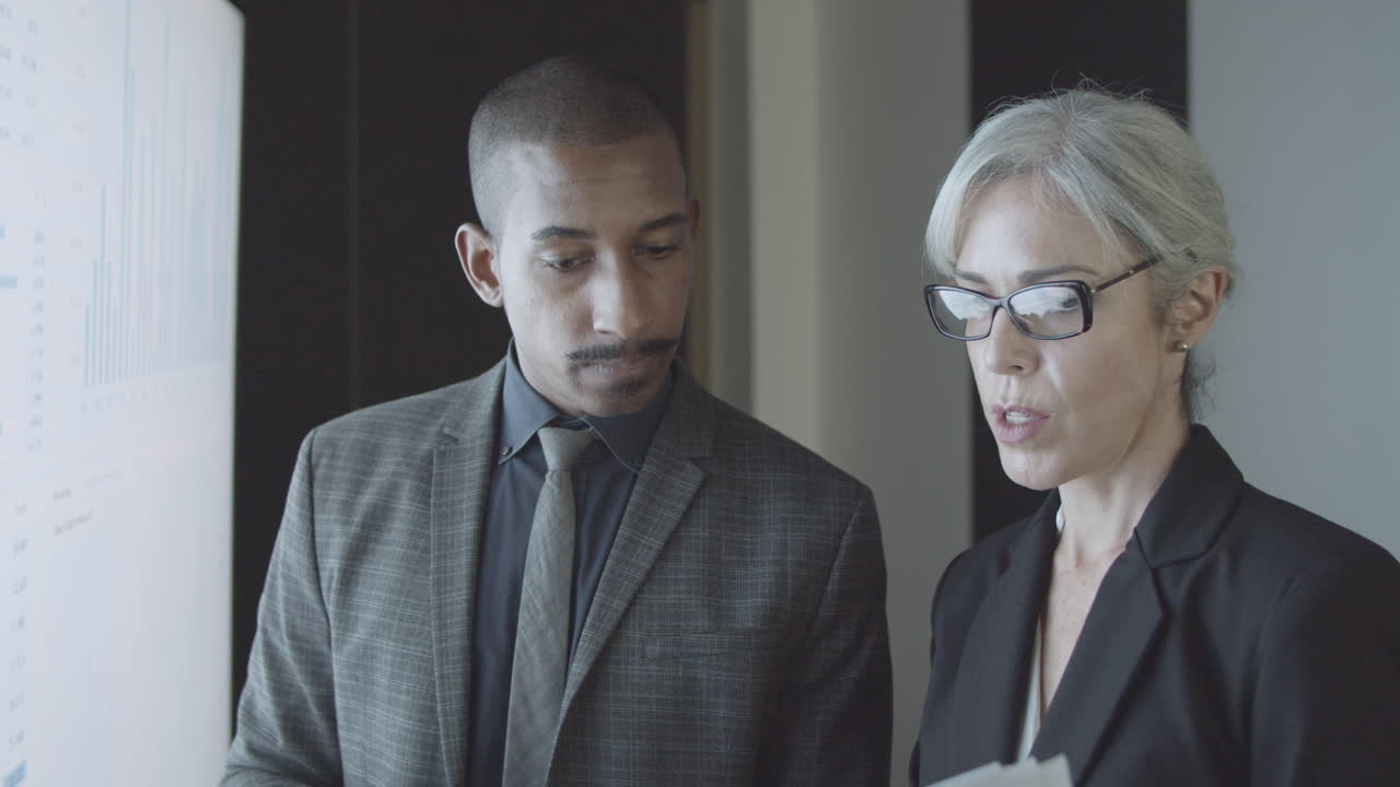 주식 시장 통계에 대해 토론하는 두 명의 금융 전문가