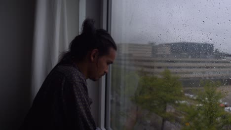 a depressed man removing himself from the window, as if he's making the decision to act on his life and face his problems