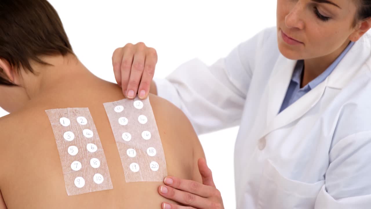 terapeuta mujer poniendo bandas en la espalda de su paciente