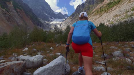 Tourist-girl-on-a-hike-to-the-glacier-in-Caucasus-mountains,-Georgia