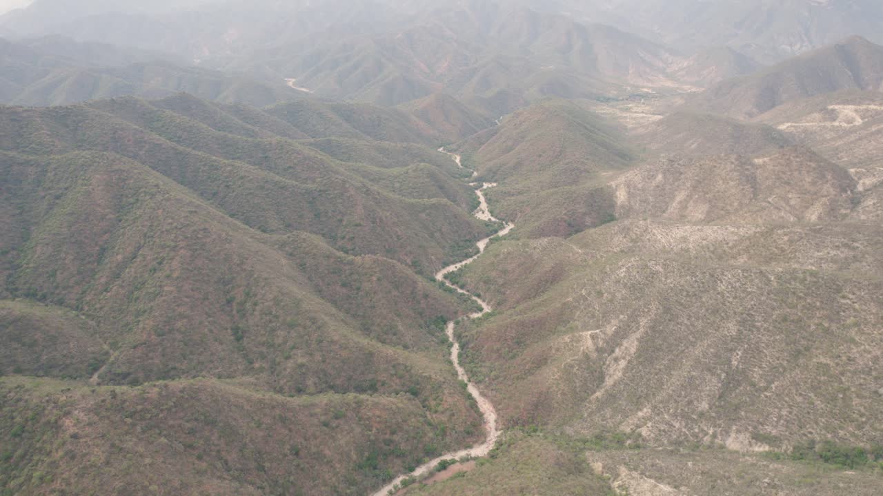 un lecho de río serpenteante entre las montañas en un soleado día de verano