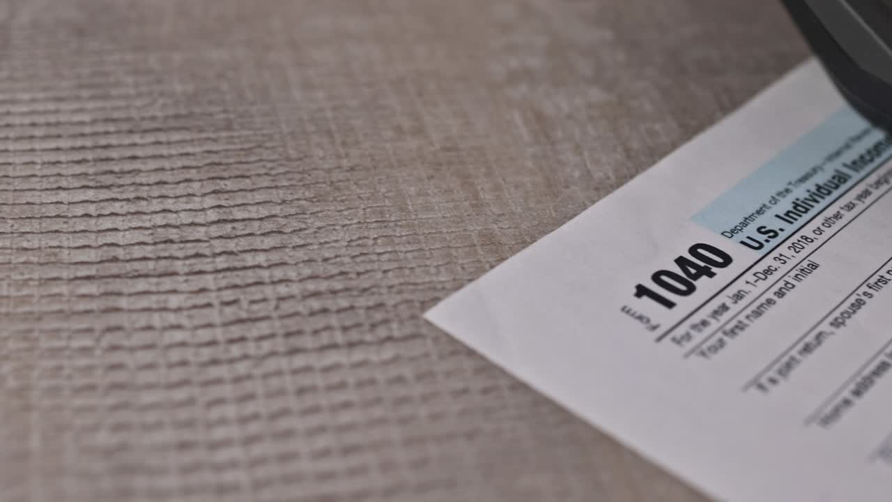 formulario de impuestos 1040 con cheque de reembolso y moneda billetes de dólar estadounidense de primer plano