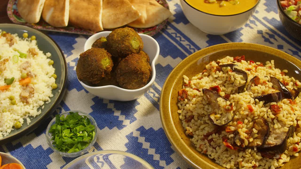 cocina árabe. bulgur con berenjena, falafel, sopa de frijoles en la mesa, cuscús con pollo. cultura tradicional de oriente medio. moutabal y ensalada de verduras en cuencos, pita. arroz delicioso con carne