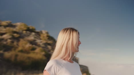 female hiker in slim sportswear with great body walking towards mountain edge