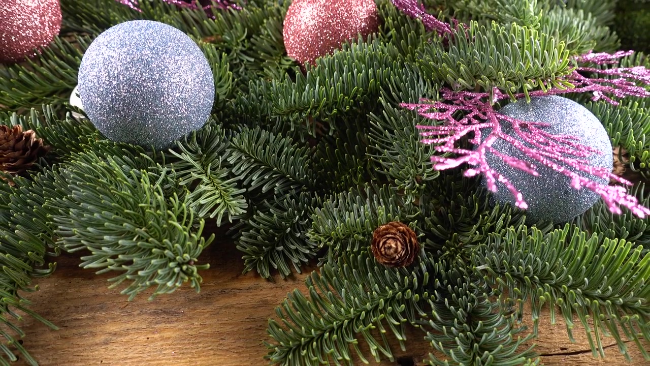 Ramo di Abies nobilis con pigne e palline di Natale su una vecchia tavola di legno vintage