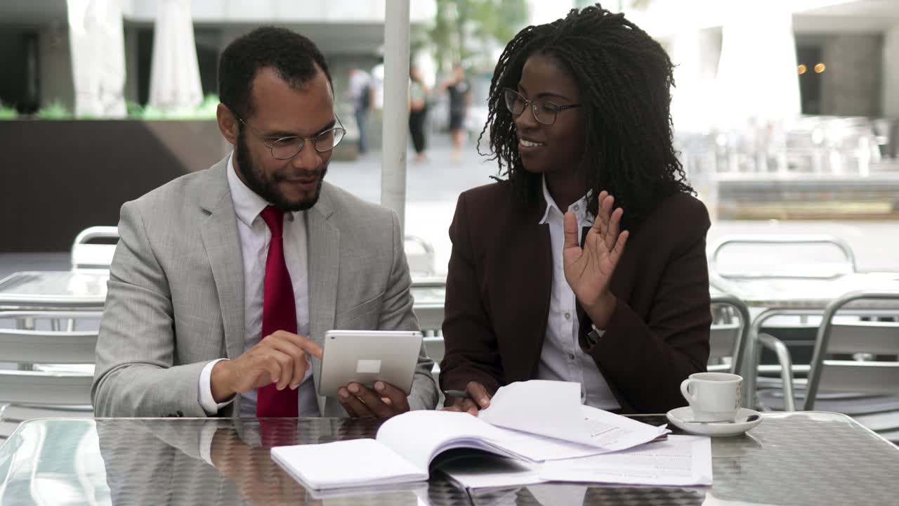 Successful lawyers talking while sitting at table with documents