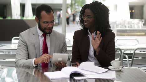 successful lawyers talking while sitting at table with documents