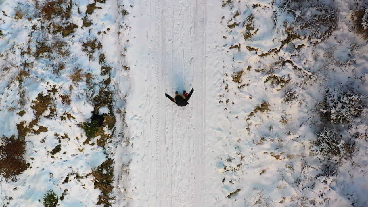 toma aérea de mujer jugando en la nieve