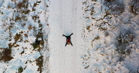 toma aérea de mujer jugando en la nieve