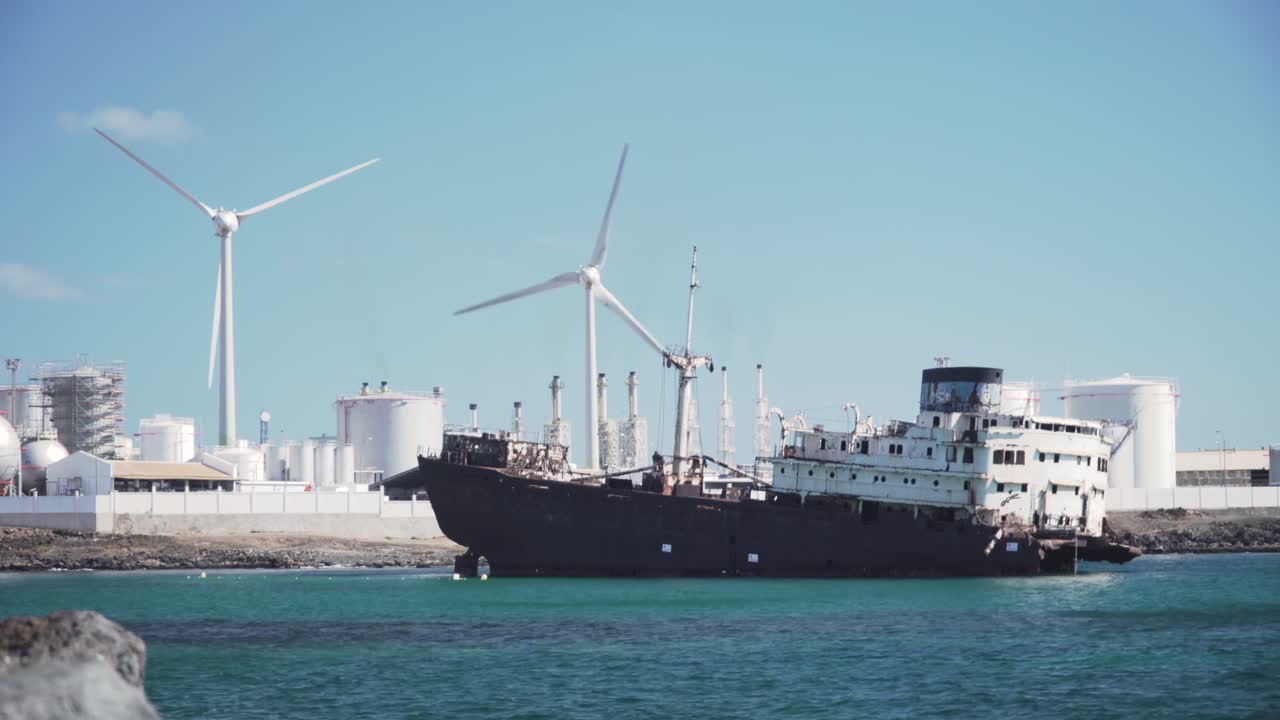 바람 터빈이 있는 해안 산업 항구에 버려진 선박
