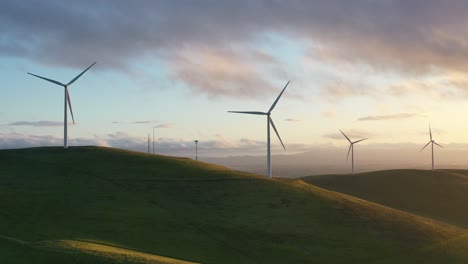 Wind-Turbines-Spinning-on-Hillside-at-Sunset