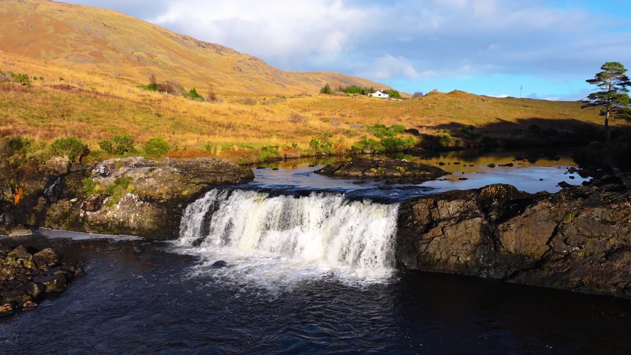4K Aerial view of Aasleagh Falls highlighting a small waterfall along a river in a remote natural setting. Captures the movement of water and surround._03