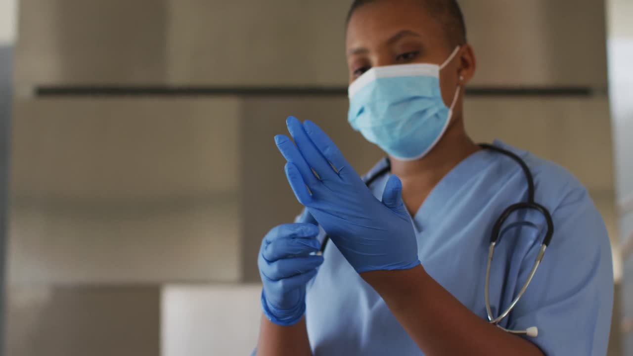 médica afroamericana con máscara facial y guantes