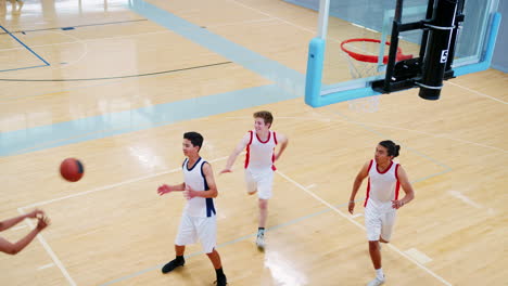 male high school basketball team scoring basket on court and celebrating