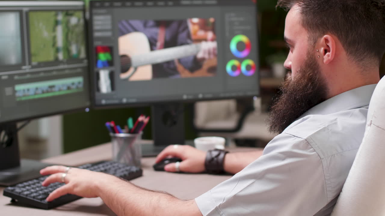 Man editing video of guitar playing on computer