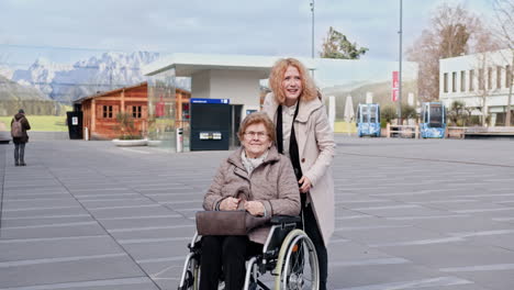 young woman assisting elderly woman in wheelchair