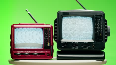 small old televisions with grey interference screen on chroma green background. close-up of vintage tv, nostalgia. gray noise screen and glitches