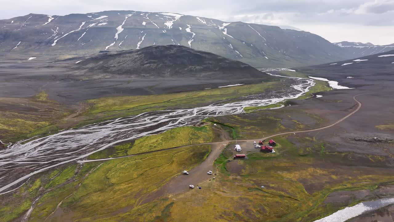 Cabins For Tourists Next To Braided River With Mountain Views In Nyjidalur, Iceland. - aerial shot