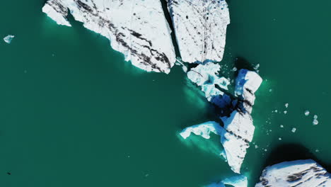 icebergs in jokulsarlon glacier lagoon on a sunny day in south iceland. - top view- aerial drone